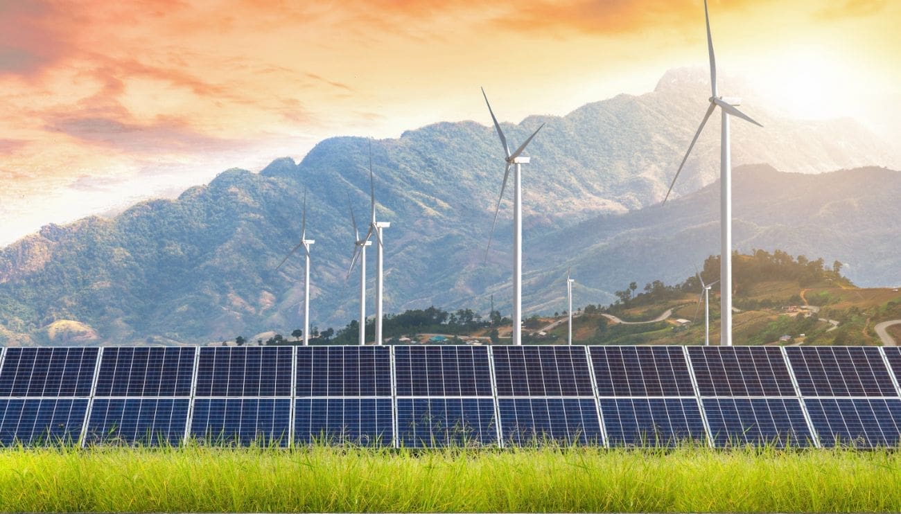 Énergie solaire photovoltaïque avec éoliennes et montagne en arrière-plan - RA-ESG