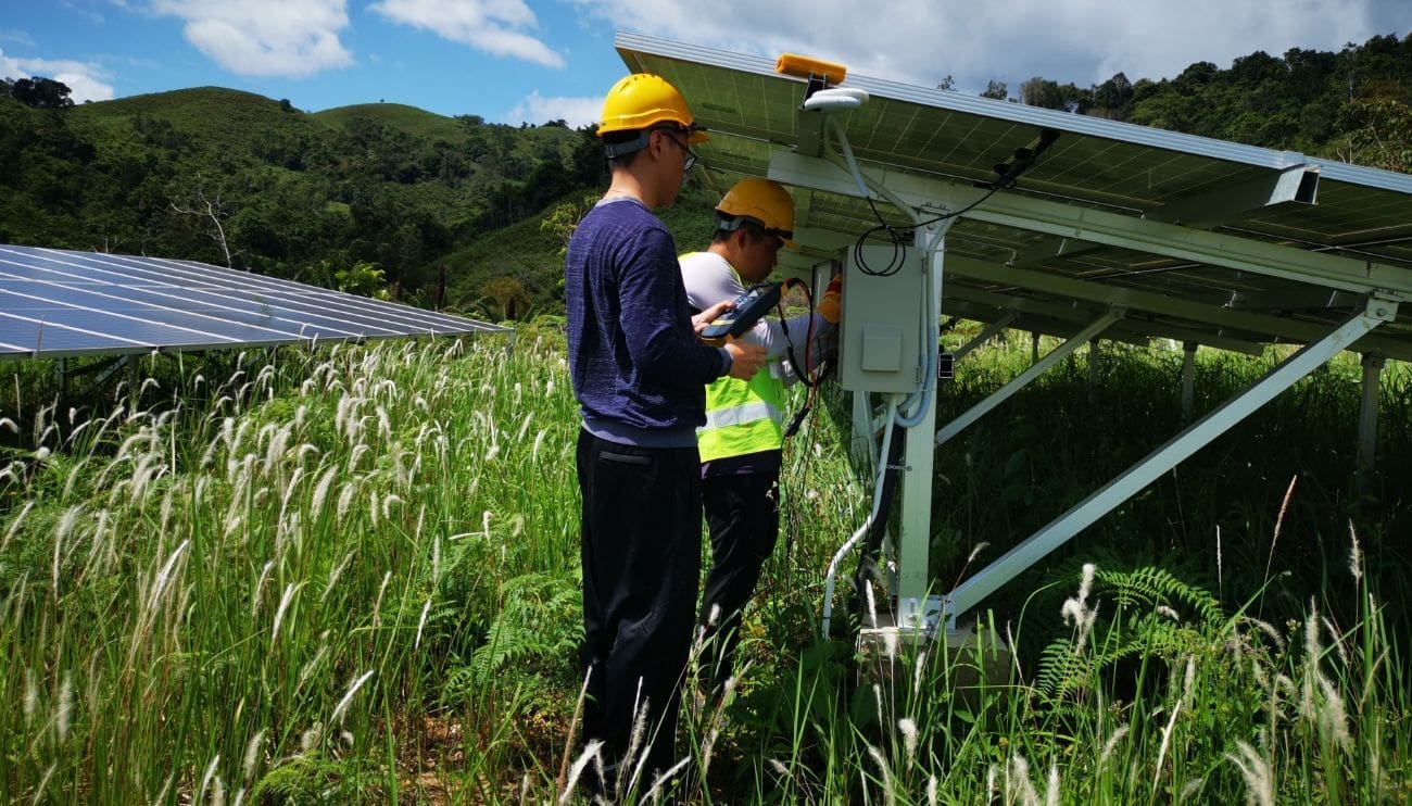 Deux hommes installent un système de panneaux solaires - RA-ESG